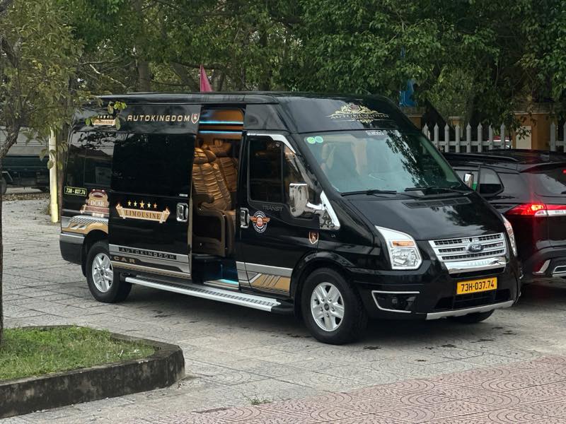 Xe limousine Ford Transit 9 chỗ màu đen của nhà xe Hiếu Thơ, cửa hông mở