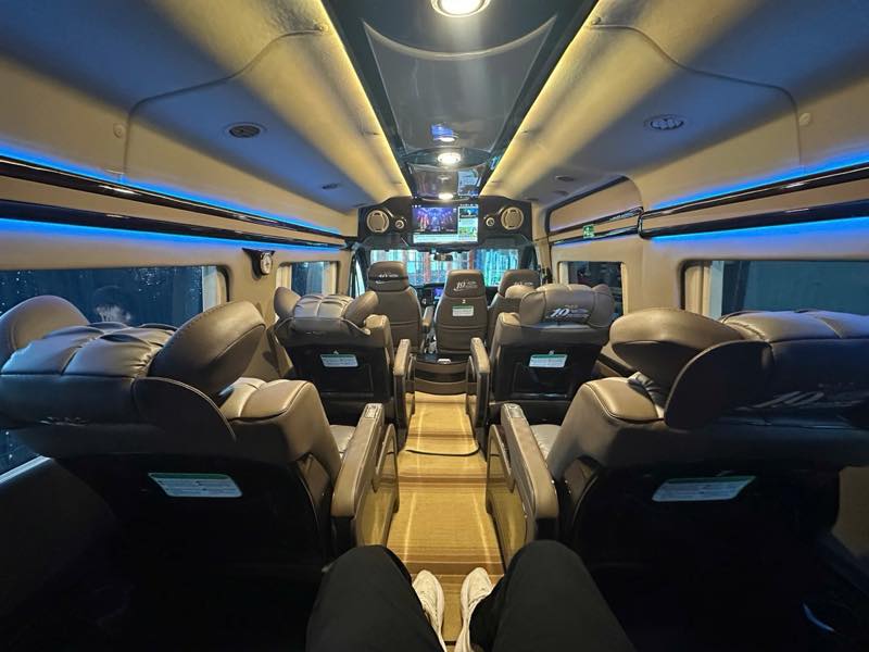 Nội thất xe limousine với ghế da ngả lưng và đèn LED xanh